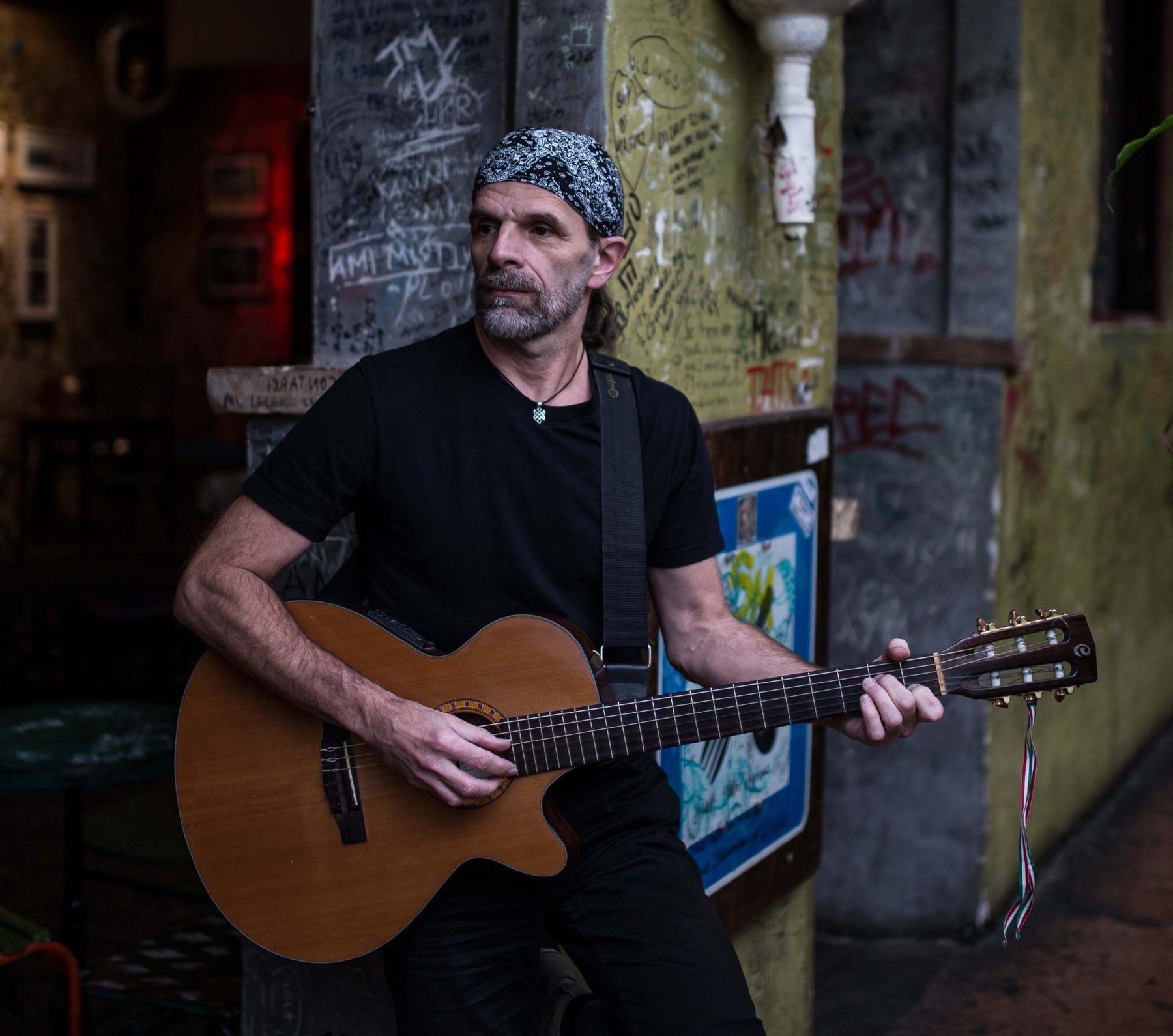 Németh Viktor akusztikus gitárral városi környezetben